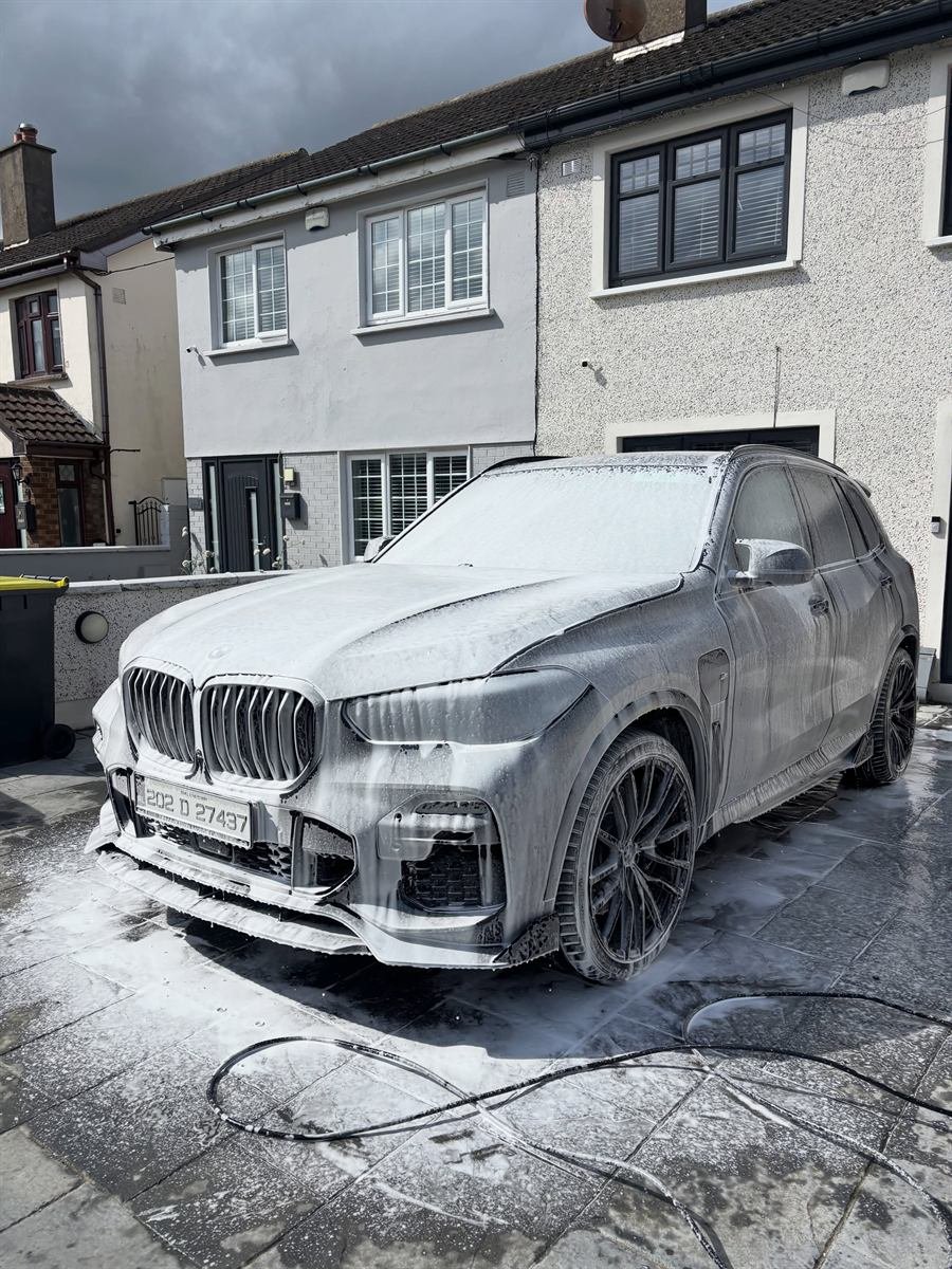 Before: car covered in snow foam mid-wash